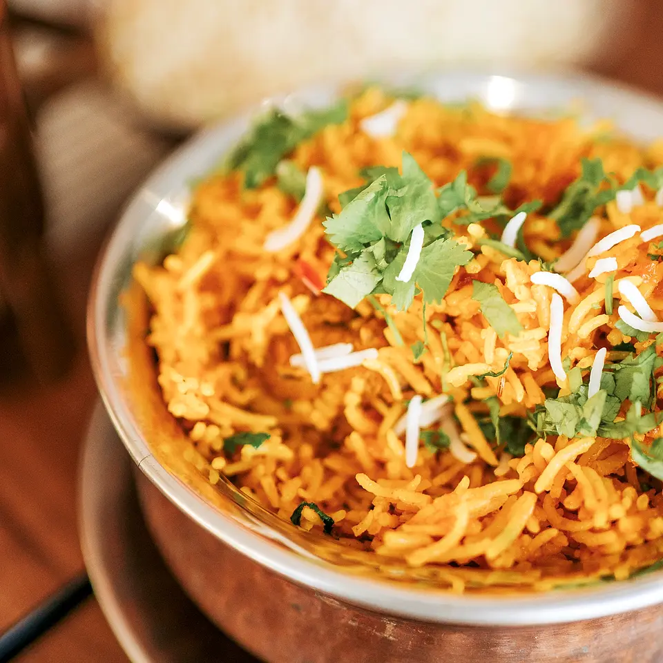 Taça de cobre com arroz basmati biryani, coentros e coco